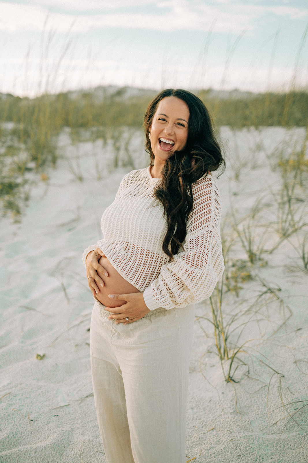 A woman laughing with joy on the beach
